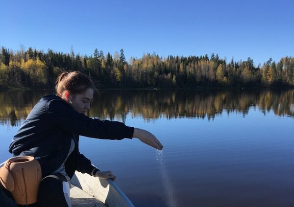 Woman sat in a boat on the river legally scattering ashes of a loved one