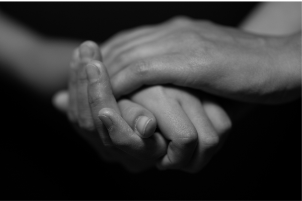 A couple holding hands as they remember and honour their baby on the anniversary of their child’s death.